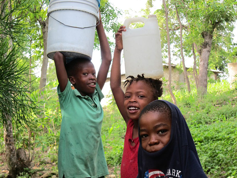 Deschapelles Haiti kids carrying water