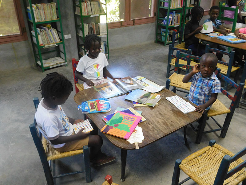 Deschapelles, Haiti library 3 kids at table