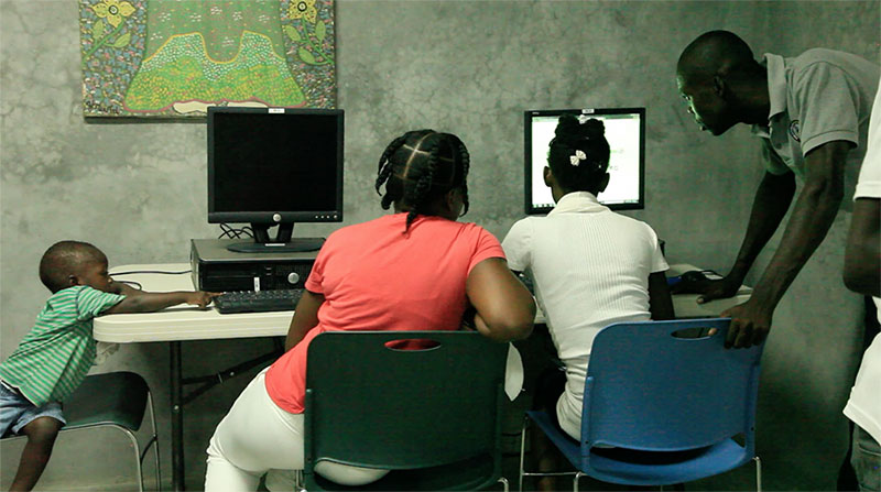 Haitian family using computer in library